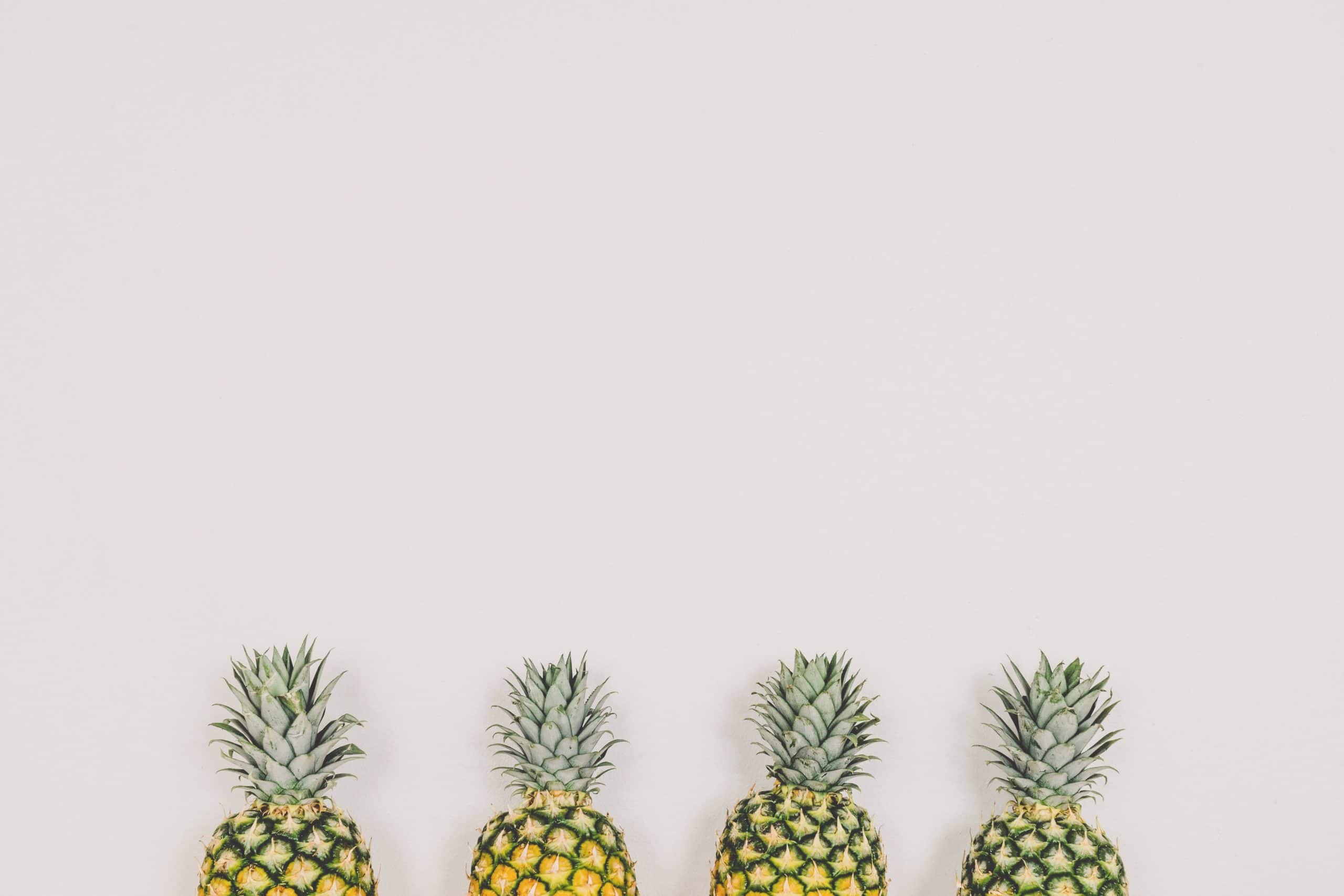 4 pineapples against a wall